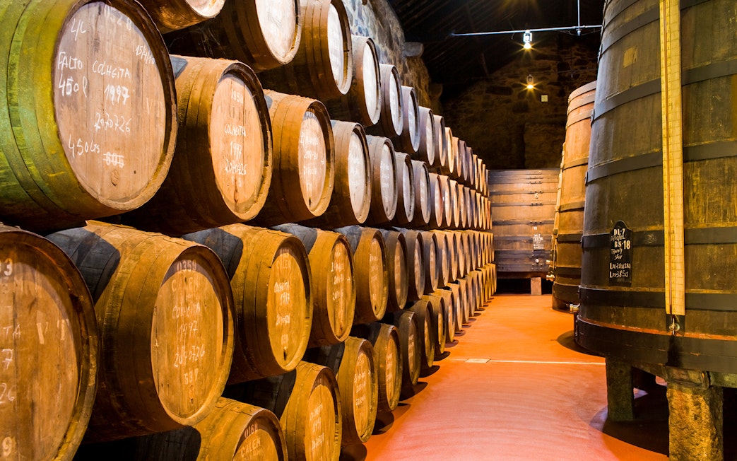 Cálem Cellars wine barrels in Porto, Portugal, part of guided tour and tasting experience.