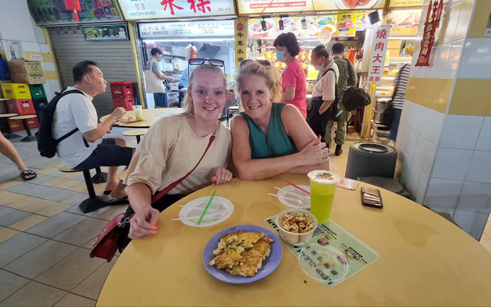 Visitors enjoying local cuisine at a food stall during the Bike and Bites Food Tour.