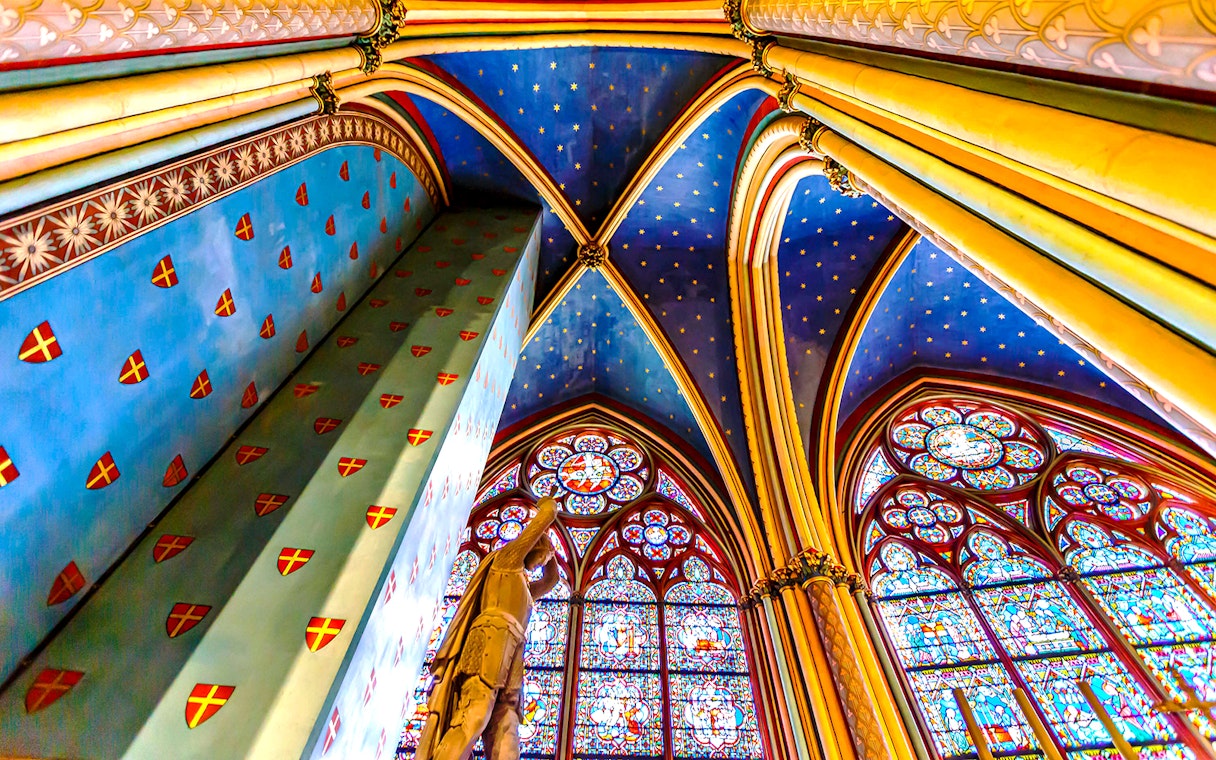 Notre-Dame Cathedral interior with stained glass windows and vaulted ceiling, Paris.