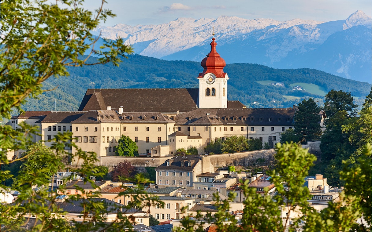Nonnberg Abbey with alpine range backdrop in Salzburg.