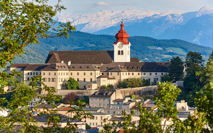Nonnberg Abbey with alpine range backdrop in Salzburg.