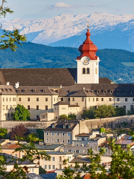 Nonnberg Abbey with alpine range backdrop in Salzburg.