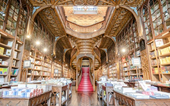 Livraria Lello interior with ornate wooden staircase and bookshelves, Porto.