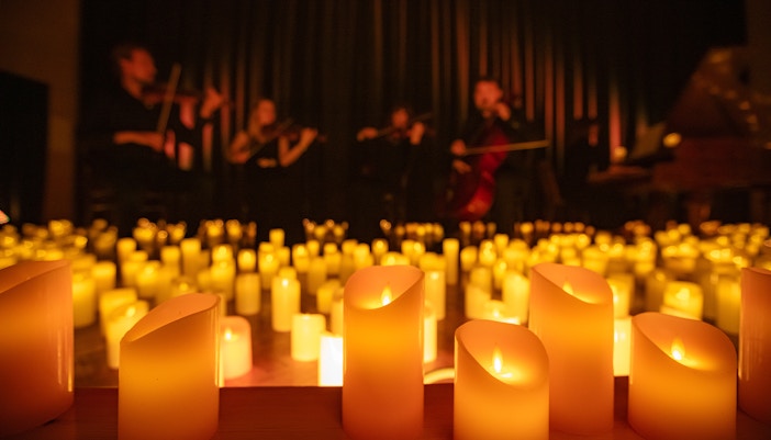 Musicians performing at a Candlelight Concert in London with string instruments.