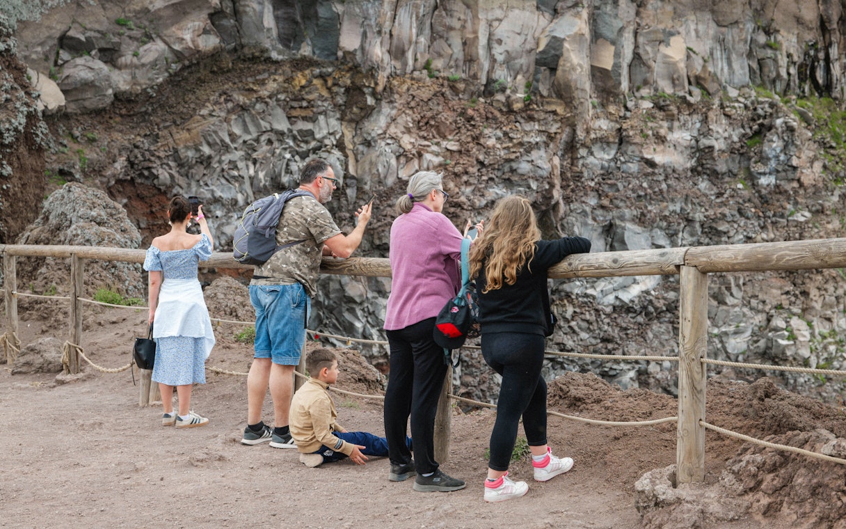 Visitors observing the crater at Mount Vesuvius, Italy.