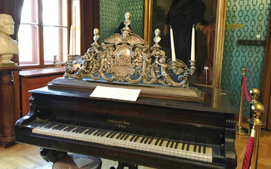 Piano with ornate candelabra inside Franz Liszt House Museum, Budapest.