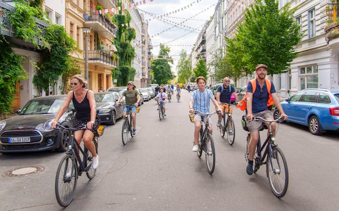 Group biking through a vibrant Berlin street on a guided tour.