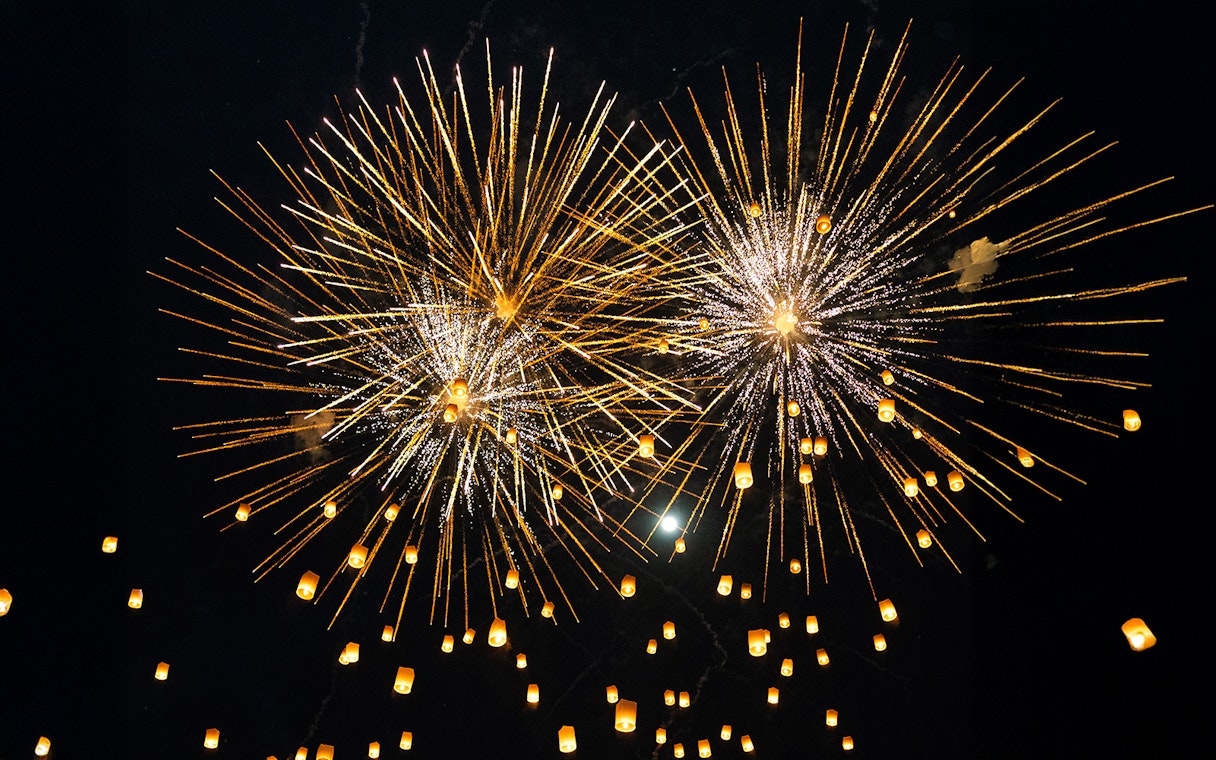 Fireworks and lanterns illuminate the night sky during Yi Peng and Loy Krathong Festival 2025.