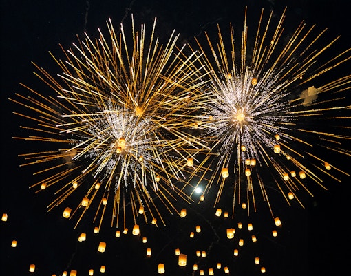Fireworks and lanterns illuminate the night sky during Yi Peng and Loy Krathong Festival 2025.