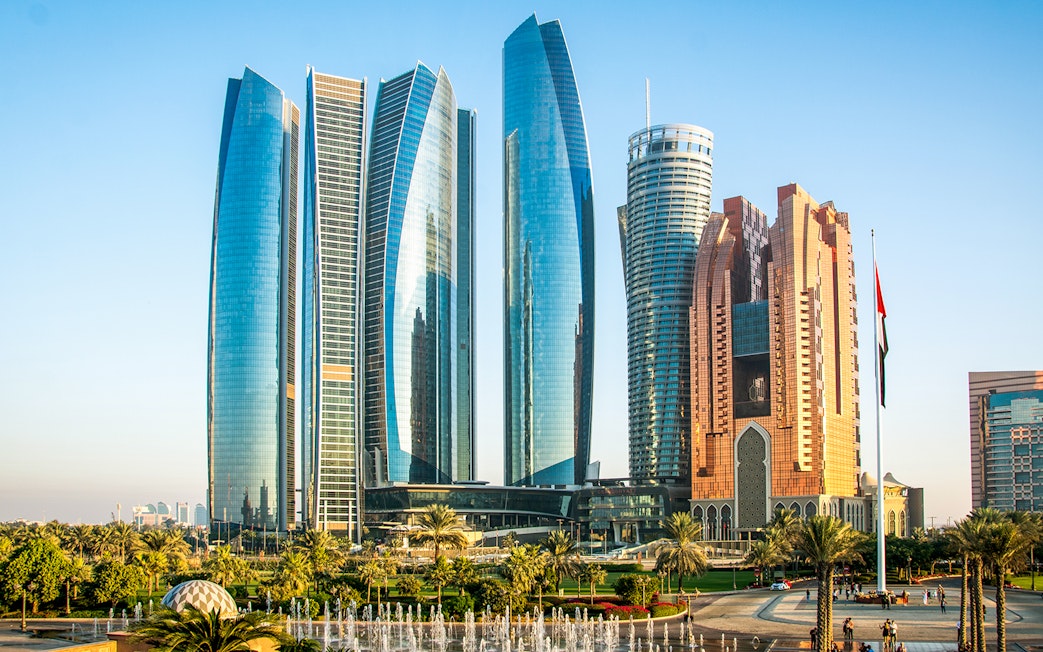 Etihad Towers skyline in Abu Dhabi with surrounding gardens and fountains.