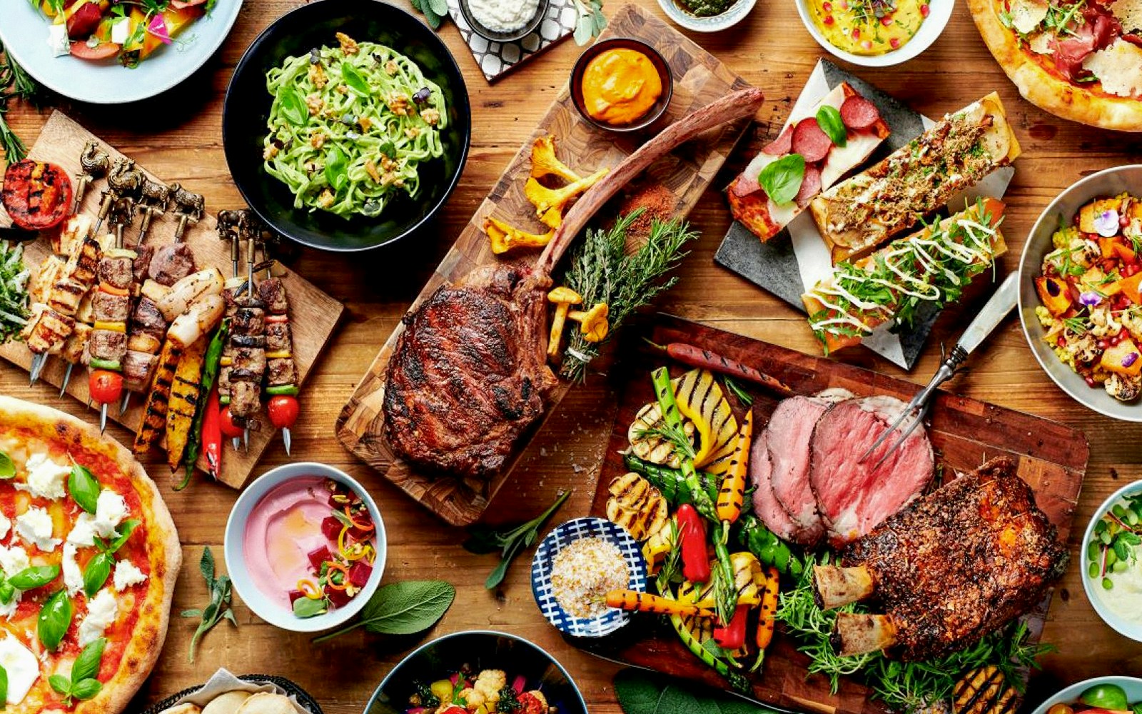 Buffet spread with grilled meats, salads, and bread.