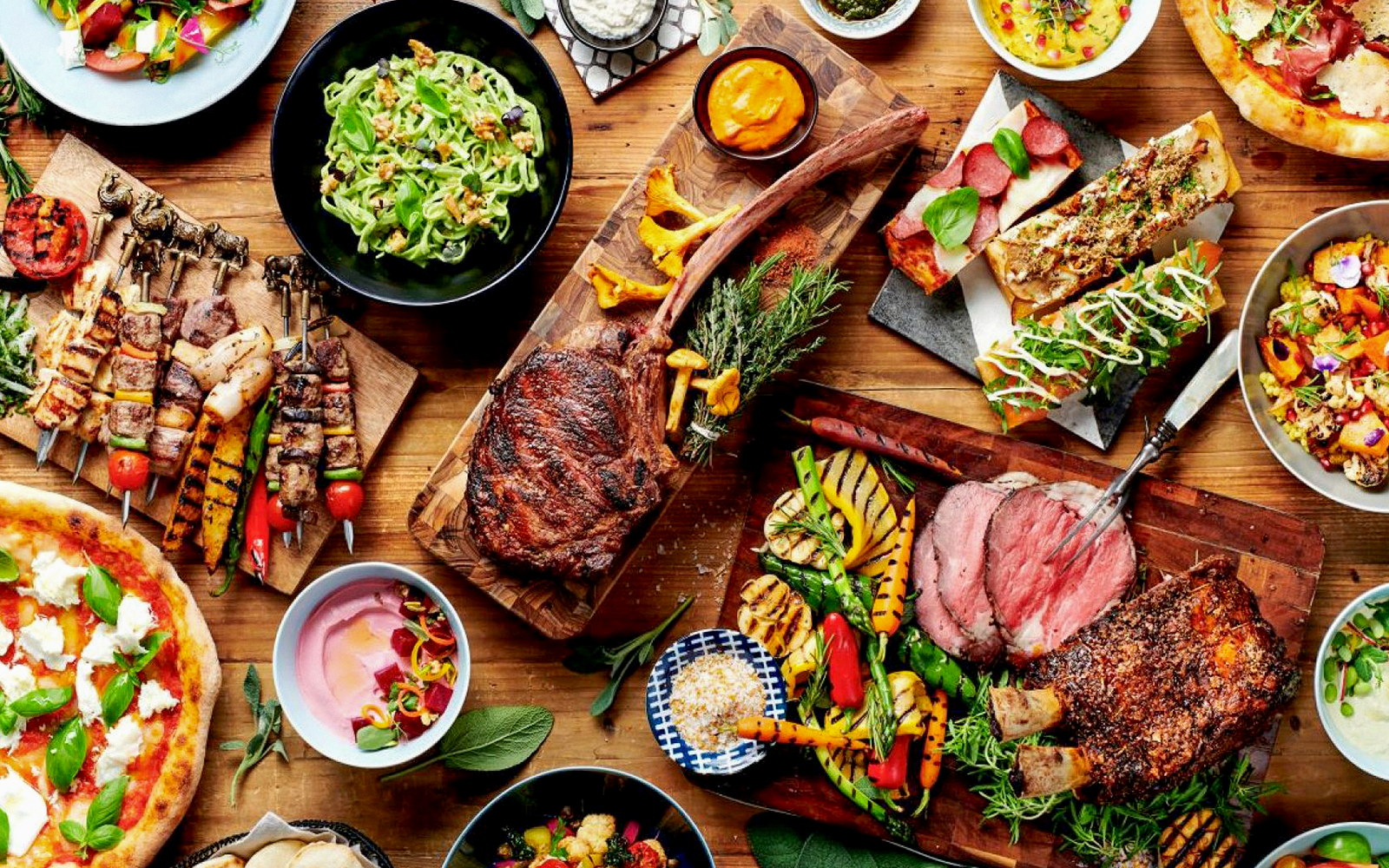 Buffet spread with grilled meats, salads, and bread.