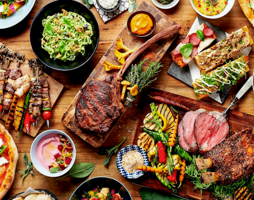 Buffet spread with grilled meats, salads, and bread at Gastronomy Buffet Dinner, Dubai.