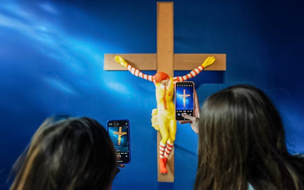 Visitors photographing a controversial sculpture at the Museum of Forbidden Art.