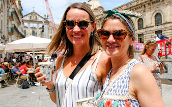 Two guests enjoying drinks at an outdoor café in Porto.