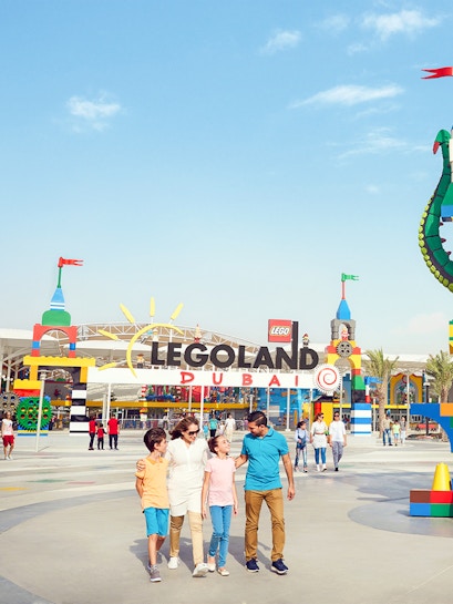 Family walking at Legoland Dubai entrance in Dubai Parks and Resorts.