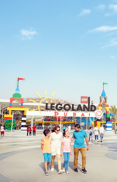 Family walking at Legoland Dubai entrance in Dubai Parks and Resorts.