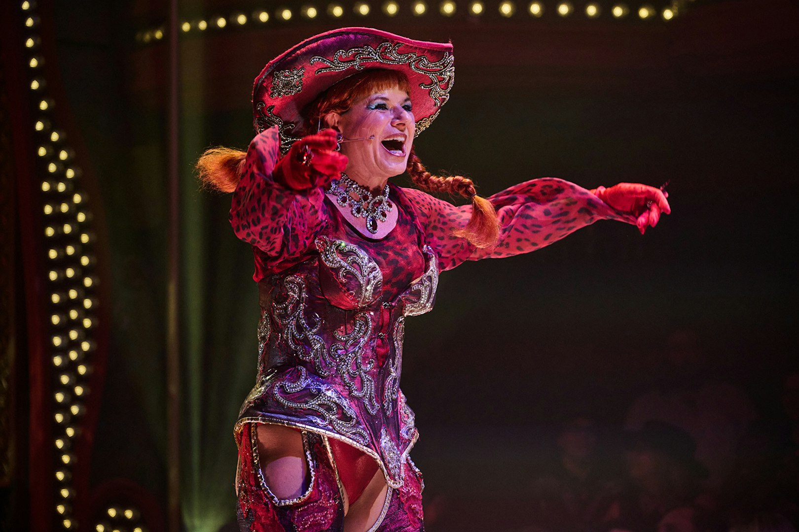 Performer in vibrant costume on stage at Atomic Saloon Show.