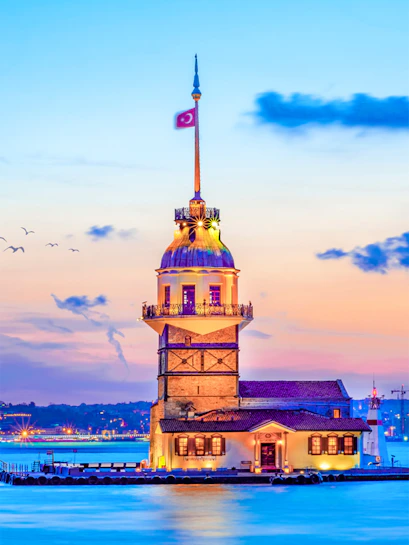 Maiden's Tower at sunset in Istanbul, Turkey, with city skyline in the background.