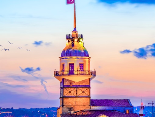 Maiden's Tower at sunset in Istanbul, Turkey, with city skyline in the background.