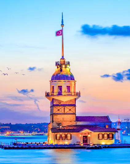 Maiden's Tower at sunset in Istanbul, Turkey, with city skyline in the background.
