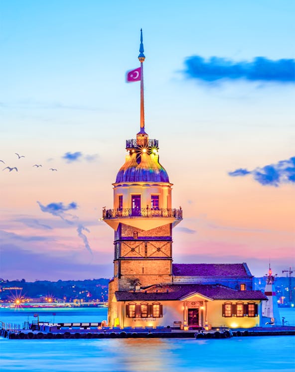 Maiden's Tower at sunset in Istanbul, Turkey, with city skyline in the background.