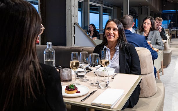 Women dining at a restaurant, enjoying wine and dessert.