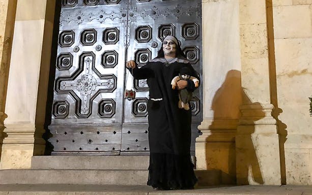 Performer in costume outside historic door during Castello District walking tour.