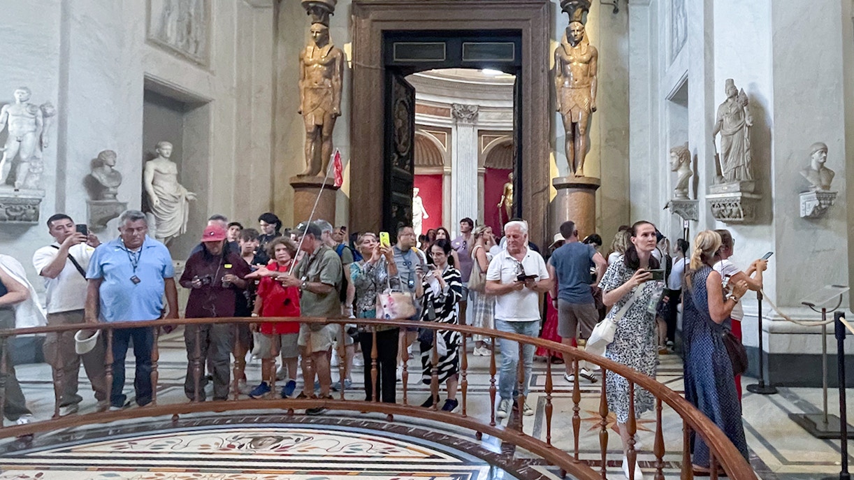 Visitors exploring the Round Hall in the Vatican Museums, Rome, Italy.