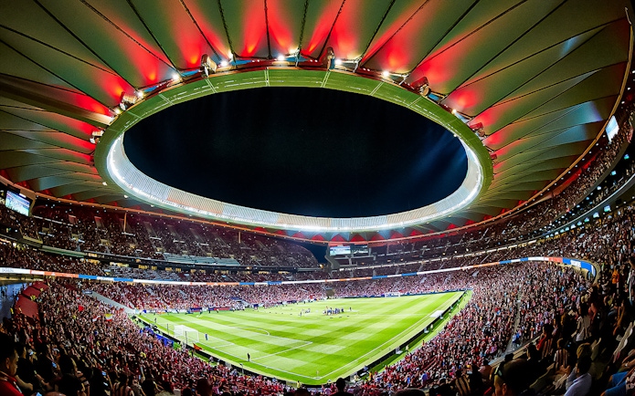 Atletico de Madrid Stadium filled with spectators during a night event.