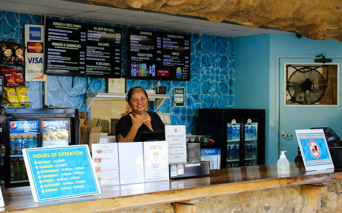 Concession stand at Hanauma Bay Nature Preserve with menu and staff member.