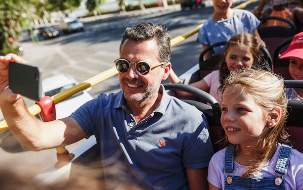 Man and children enjoying Reykjavik hop-on hop-off bus tour.