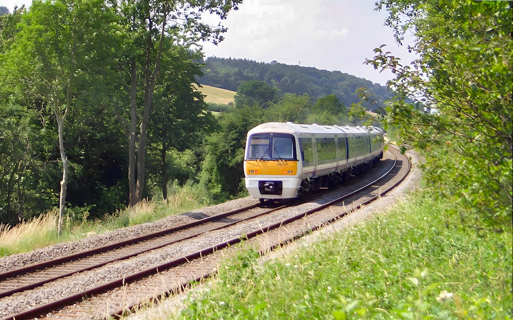 Train traveling through lush countryside near Warwick Castle.