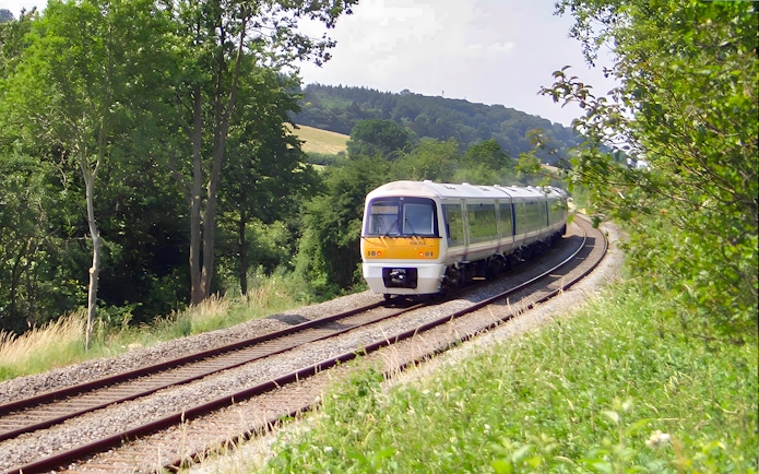 Train traveling through lush countryside near Warwick Castle.
