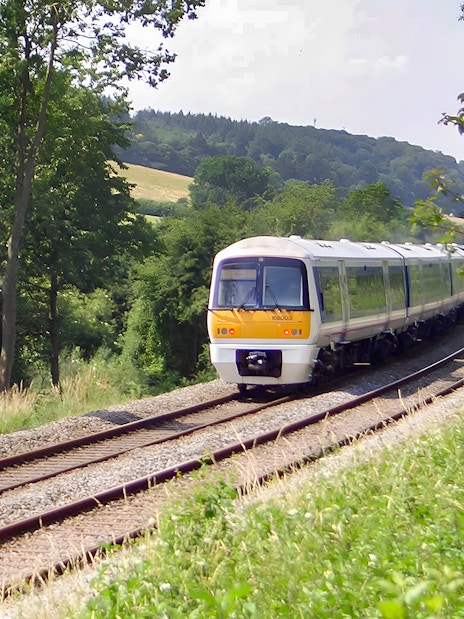 Train traveling through lush countryside near Warwick Castle.