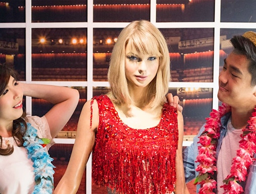 Wax figure at Madame Tussauds Singapore with visitors.