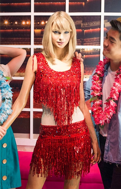 Wax figure at Madame Tussauds Singapore with visitors.