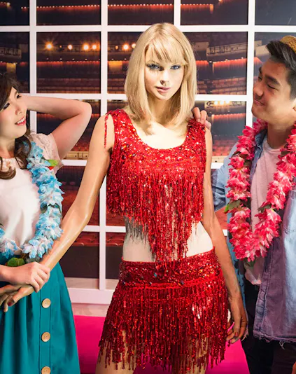 Wax figure at Madame Tussauds Singapore with visitors.
