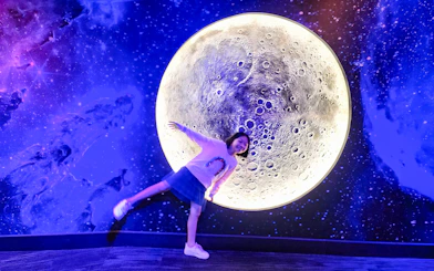 Child posing in front of a moon exhibit at Petrosains, The Discovery Centre, Kuala Lumpur.