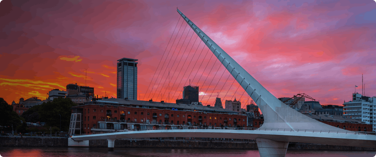 Puente de la Mujer at sunset in Buenos Aires, Argentina with city skyline.