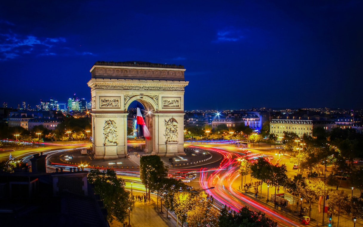 Arc de Triomphe illuminated at night during Paris Illumination Tour.