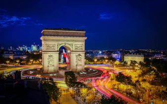 Arc de Triomphe illuminated at night during Paris Illumination Tour.