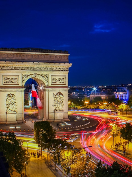 Arc de Triomphe illuminated at night during Paris Illumination Tour.