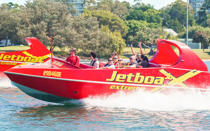 Jet boat with passengers enjoying a thrilling ride on the water.