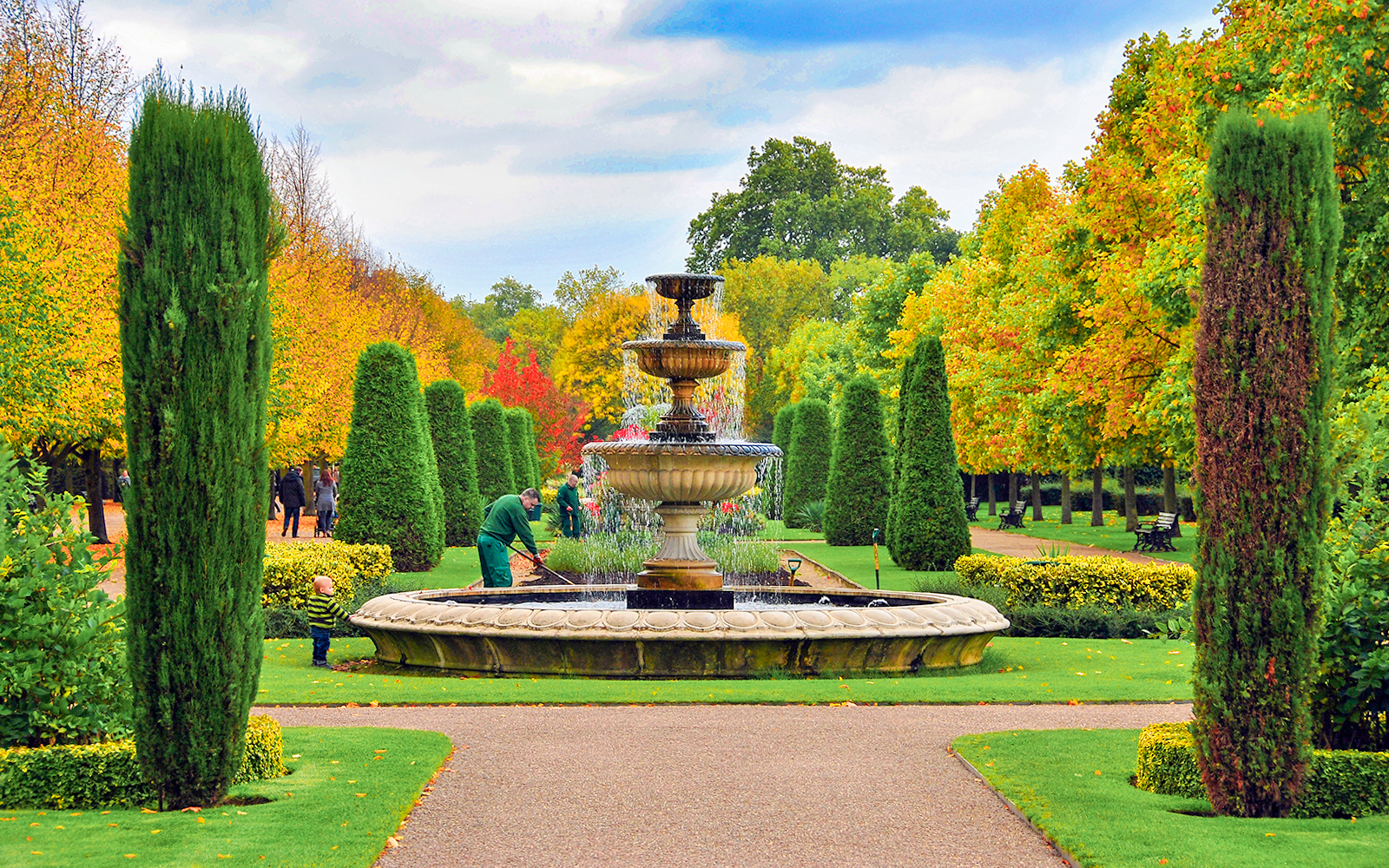 Fountain in a landscaped garden with autumn trees, Hyde Park, London.