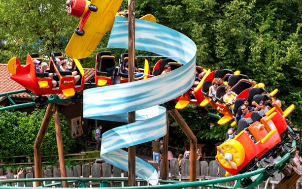 Roller coaster ride at Leolandia with colorful airplane-themed cars.