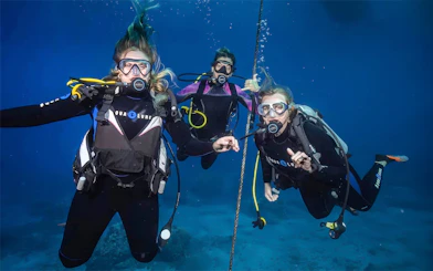 Beginners scuba diving lesson in Maui with three divers underwater.
