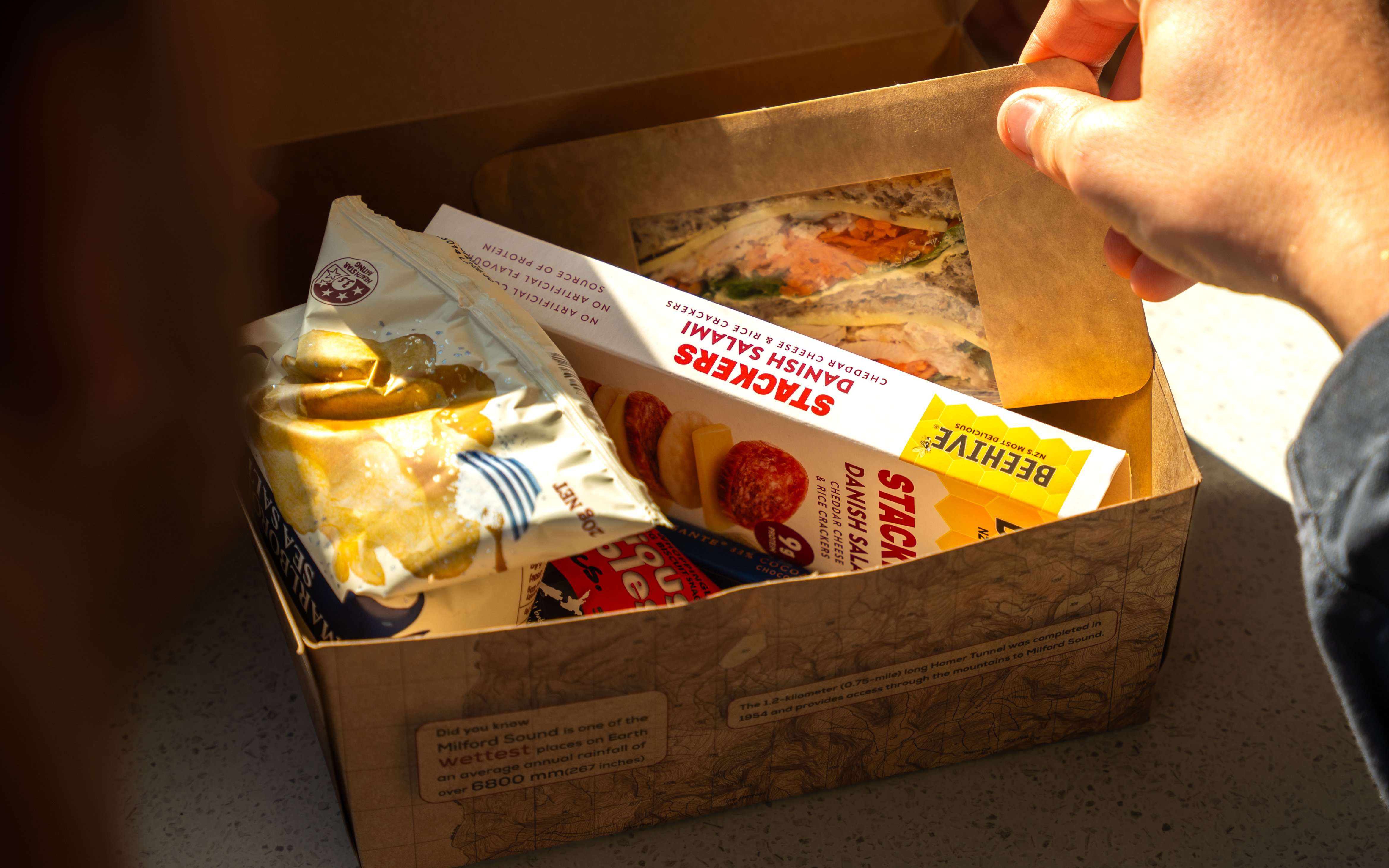 Lunch box with sandwich and snacks on Milford Sound Extended Cruise.