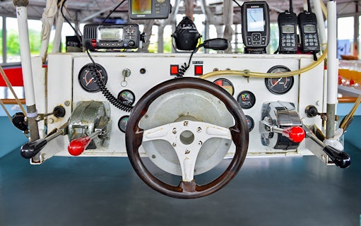 Boat steering wheel and control panel on Dragon Sunset Cruise.