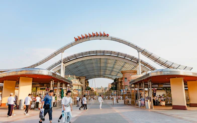 Entrance to Universal Studios Japan with roller coaster track overhead.